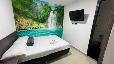 a bedroom with a waterfall mural on the wall at Hotel Jardin de Laureles Jeps in Medellín