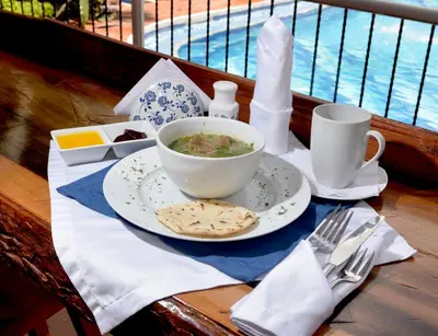 a table with a bowl of soup and a plate of food at Hotel El Virrey Boutique Honda in Honda