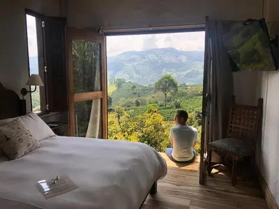 a person sitting on the floor in a room with a large window at Casa Santamaria Hotel Campestre in Jericó