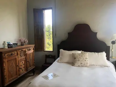 a bedroom with a bed with a wooden dresser and a window at Casa Santamaria Hotel Campestre in Jericó