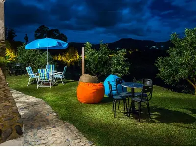 a patio with a table and chairs and an umbrella at Casa Santamaria Hotel Campestre in Jericó