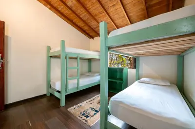 a bedroom with two bunk beds and a wooden ceiling at The Secret Buddha in Medellín