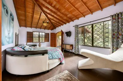 a bedroom with a bed and a chair at The Secret Buddha in Medellín