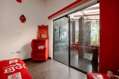 a room with a glass door and a red furniture at The Secret Buddha in Medellín