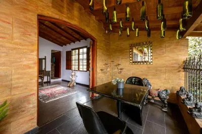 a dining room with wooden walls and a table and chairs at The Secret Buddha in Medellín