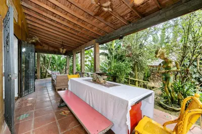 a porch with a table and chairs and a statue at The Secret Buddha in Medellín
