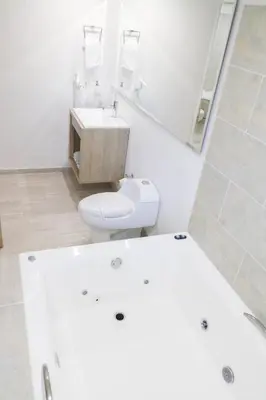 a white bathroom with a toilet and a sink at Hotel Boutique Laureles Medellin (HBL) in Medellín