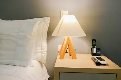 a lamp on a night stand next to a bed at Hotel Boutique Laureles Medellin (HBL) in Medellín