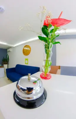a red flower in a vase on a table at Hotel Boutique Laureles Medellin (HBL) in Medellín