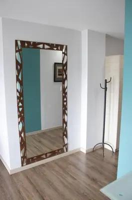 a mirror in a room with a wooden floor at Apartahotel Millennials in Manizales