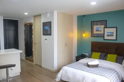 a bedroom with a bed and blue walls at Apartahotel Millennials in Manizales