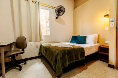 a bedroom with a bed and a desk and a window at Poblado Guest House in Medellín