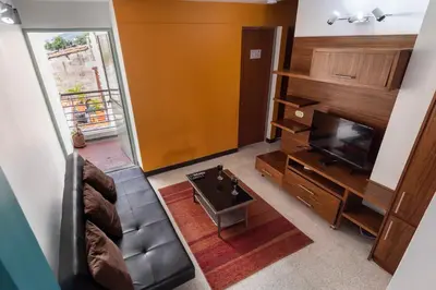 a view of a living room with a television and a couch at Poblado Guest House in Medellín