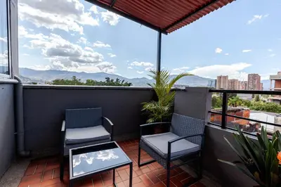 a balcony with two chairs and a table at Poblado Guest House in Medellín