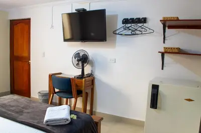 a room with a desk and a tv on the wall at Hotel Caldas Plaza in Caldas