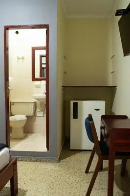 a bathroom with a toilet and a sink and a mirror at Hotel Caldas Plaza in Caldas