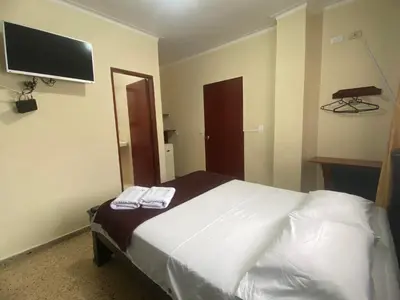 a bedroom with a bed and a flat screen tv at Hotel Caldas Plaza in Caldas