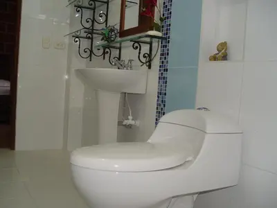 a white bathroom with a toilet and a sink at Casa Hotel Portón Campestre in Jardin