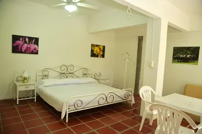 a bedroom with a white bed and a table at Alojamiento rural el Refugio en santagueda in Santagueda