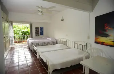 a room with three beds and a balcony with a ceiling fan at Alojamiento rural el Refugio en santagueda in Santagueda