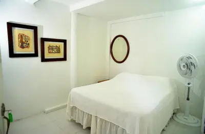 a white bedroom with a bed and a fan at Alojamiento rural el Refugio en santagueda in Santagueda