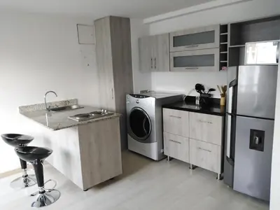 a kitchen with a refrigerator and a washer and dryer at San Peter Suites in Medellín