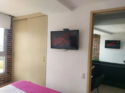 a room with a television on the wall at San Peter Suites in Medellín