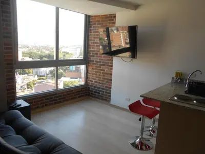 a living room with a couch and two large windows at San Peter Suites in Medellín