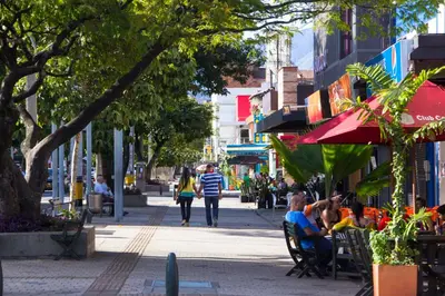 a group of people sitting in chairs on a city street at San Peter Suites in Medellín