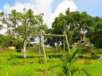 a playground with a swing in a park at Cabañas y Flores in Jericó