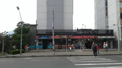 a person crossing a street in front of a building at Apartamento En Sabaneta in Sabaneta