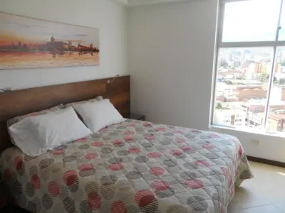 a bedroom with a bed with a large window at San Peter Apartments in Medellín