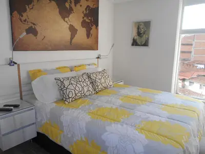 a bedroom with a bed and a map on the wall at San Peter Apartments in Medellín