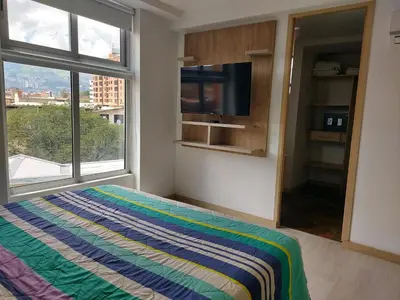 a bedroom with a bed and a large window at San Peter Apartments in Medellín