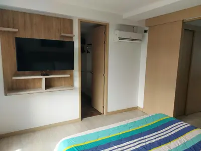 a bedroom with a flat screen tv and a bed at San Peter Apartments in Medellín