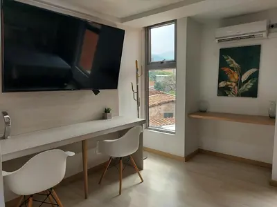 a living room with a desk with a flat screen tv at San Peter Family Suites in Medellín