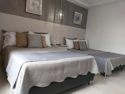two beds sitting next to each other in a bedroom at San Peter Family Suites in Medellín