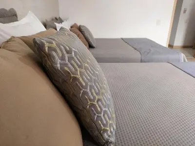 two beds with pillows on them in a bedroom at San Peter Family Suites in Medellín