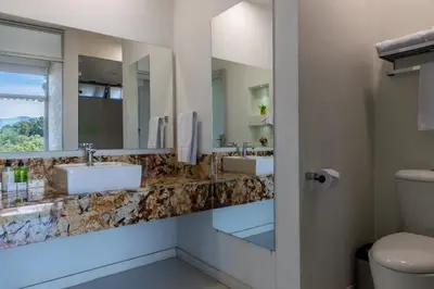 a bathroom with two sinks and two mirrors at Terra Biohotel in Medellín