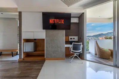 an office with a television on a wall in a building at Terra Biohotel in Medellín