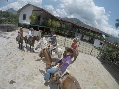 a group of people riding horses in front of a building at Golden Frog Manizales in Manizales