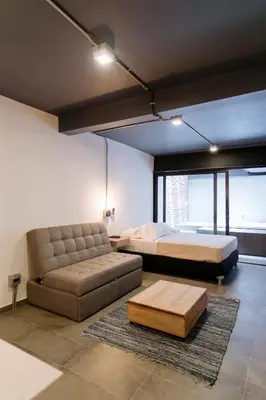 a bedroom with two beds and a couch at Soy Local Provenza in Medellín