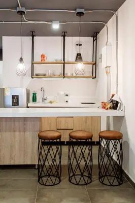 a kitchen with two bar stools and a sink at Soy Local Provenza in Medellín