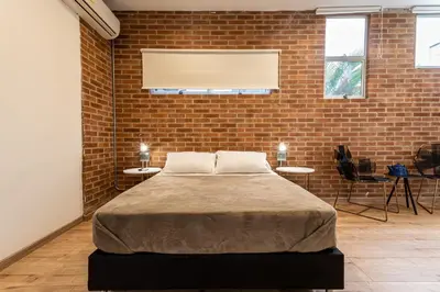 a bedroom with a bed in a brick wall at Soy Local Provenza in Medellín