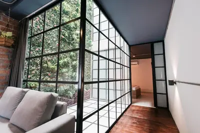 a room with a large window and a couch at Soy Local Provenza in Medellín