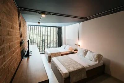 a hotel room with two beds and a window at Soy Local Provenza in Medellín