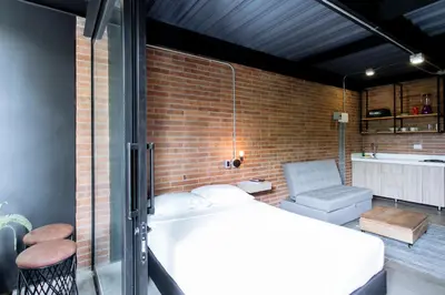 a room with a bed and a brick wall at Soy Local Provenza in Medellín