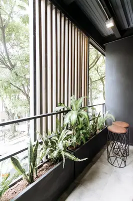 a balcony with plants and a large window at Soy Local Provenza in Medellín