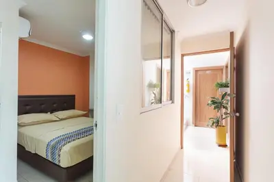 a bedroom with a bed and a hallway with a mirror at Apartamentos Laureles de la 70 in Medellín