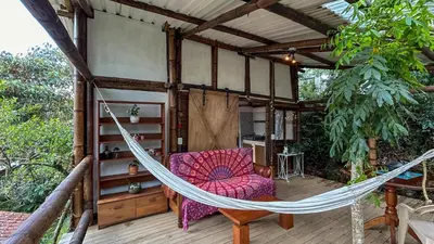 a hammock on the deck of a house at Refugio en las Nubes in Santa Elena
